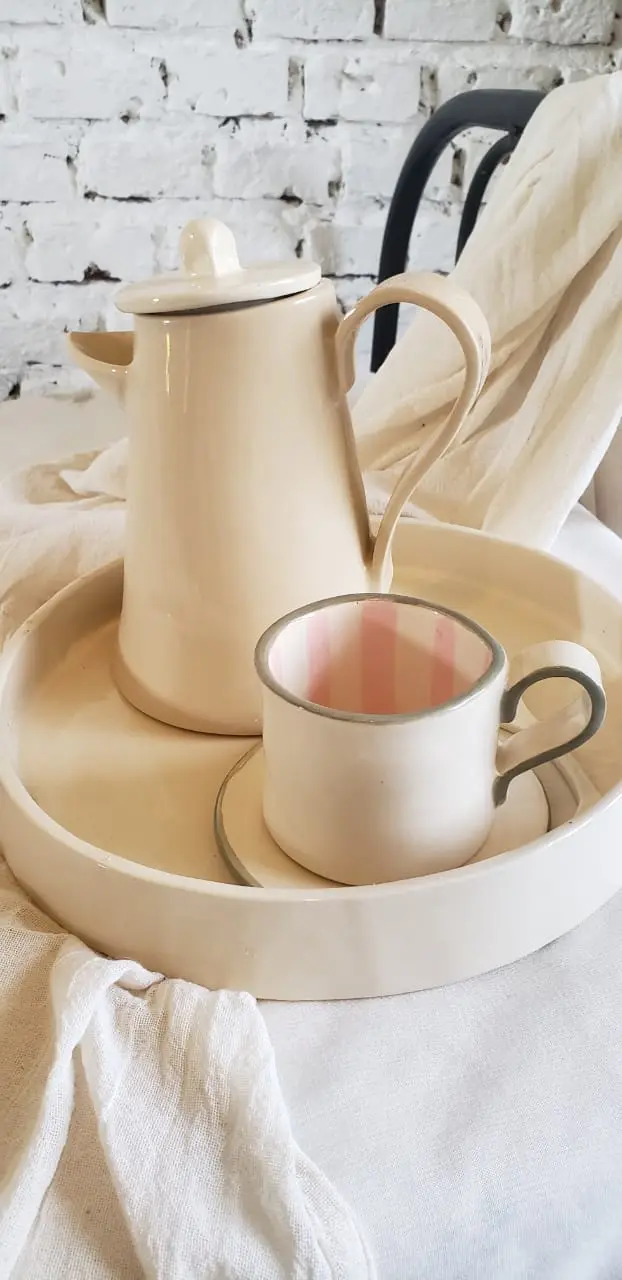 Cafetera y taza con rayas rosadas por dentro
