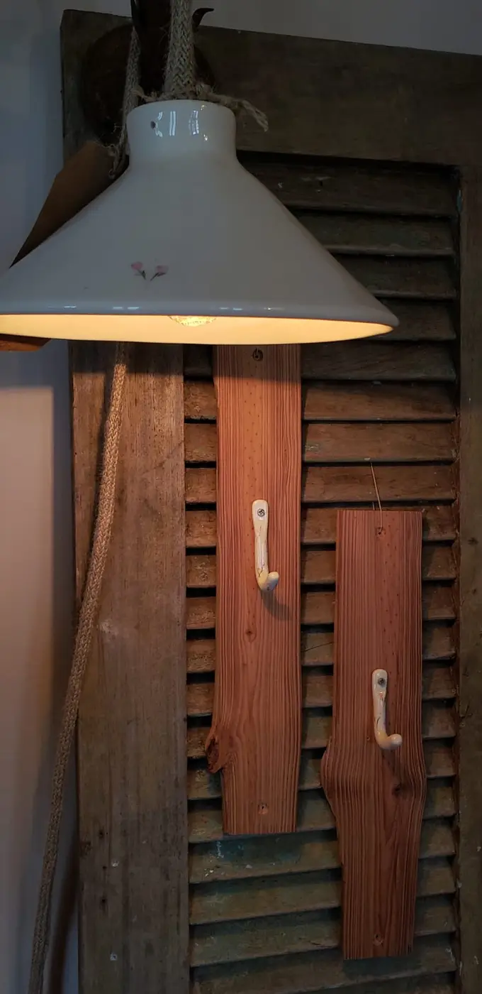 Lámpara de cerámica y perchas sobre una persiana de madera antigua