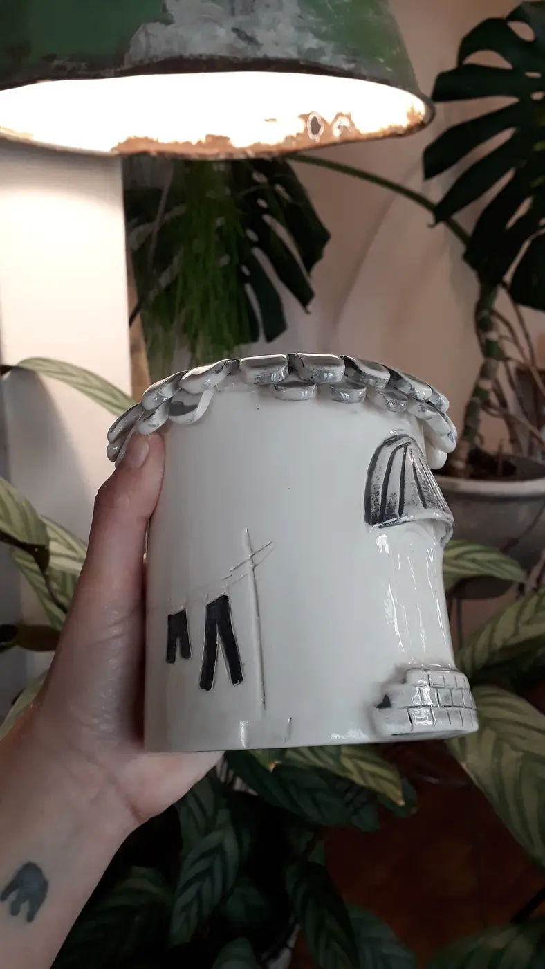 Maceta de cerámica con forma de casita, modelada a mano
